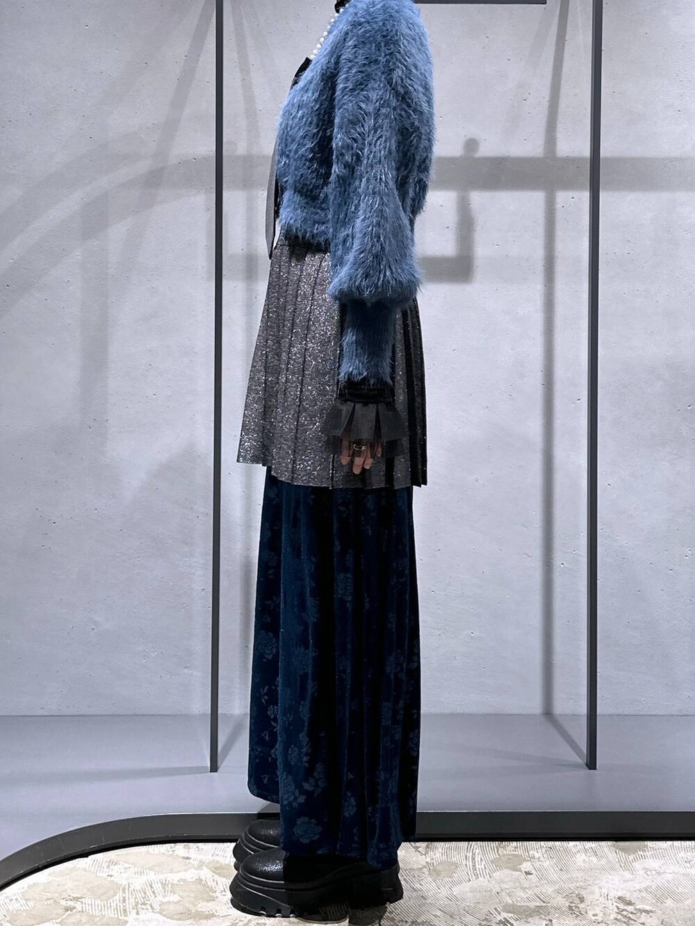 ブラック系のネクタイ、ブルー系のニット/セーター、ブラック系のTシャツ/カットソーを着用したレディースの冬コーディネートの2枚目の写真