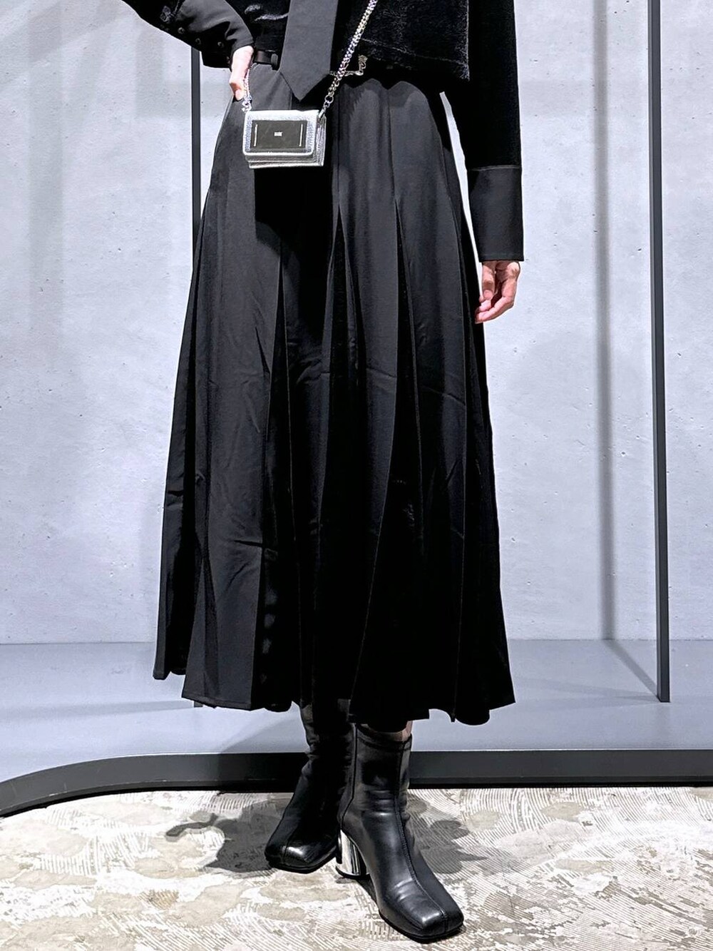 ブラック系のブーツ、ブラック系のシャツ/ブラウス、ブラック系のスカートを着用したレディースの秋コーディネートの6枚目の写真