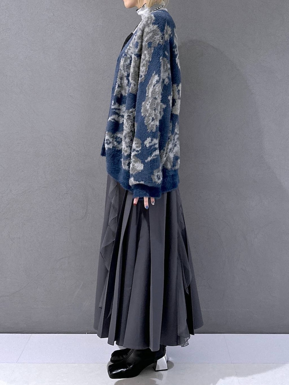 ブラック系のネクタイ、ブルー系のカーディガン/ボレロ、ブラック系のブーツを着用したレディースの秋コーディネートの2枚目の写真