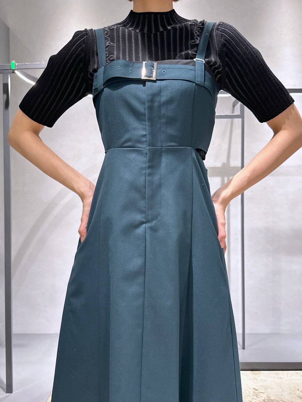 ブラック系のサンダル、グレー系のニット/セーター、グリーン系のワンピースを着用したレディースの春コーディネートの2枚目の写真