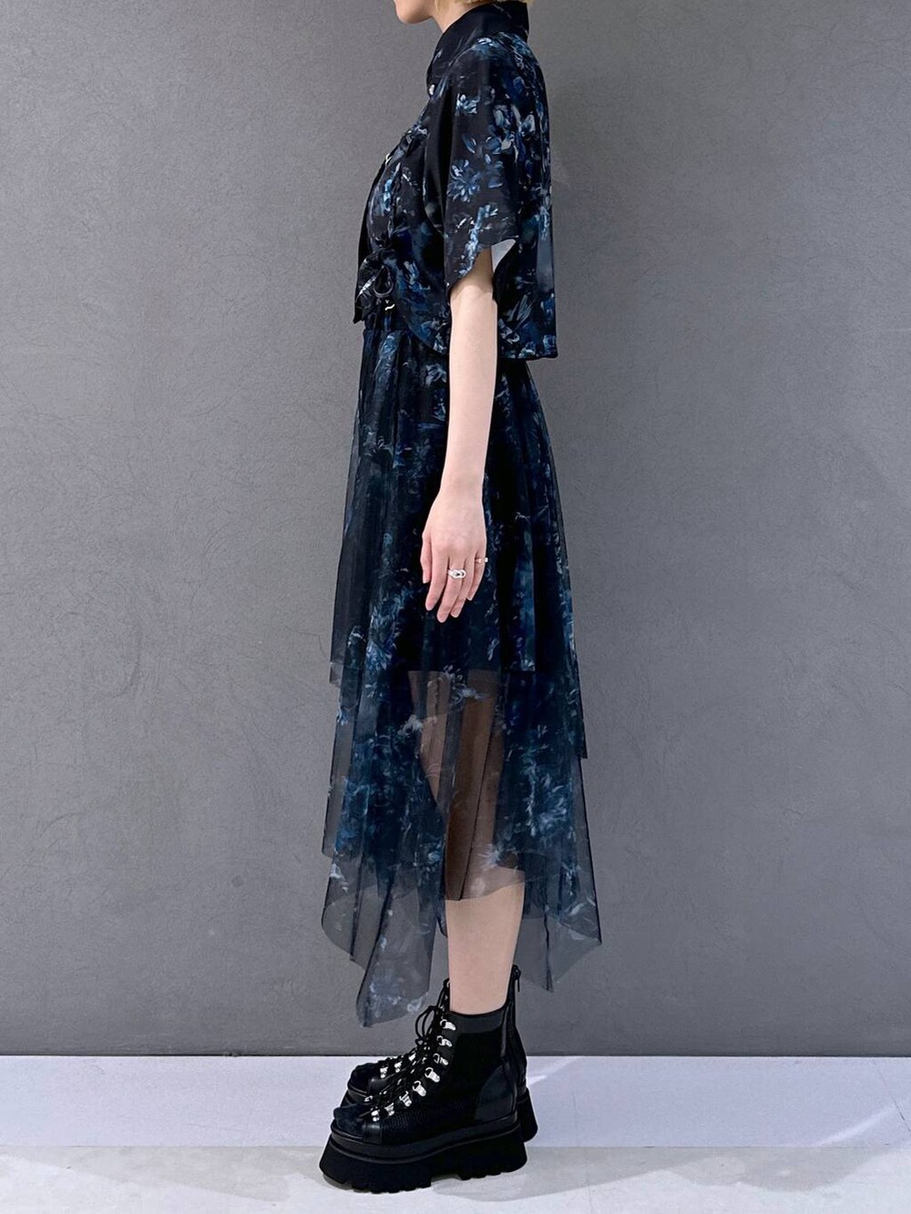 ブラック系のサンダル、ブルー系のシャツ/ブラウス、ブラック系のブローチ/コサージュを着用したレディースの春コーディネートの2枚目の写真