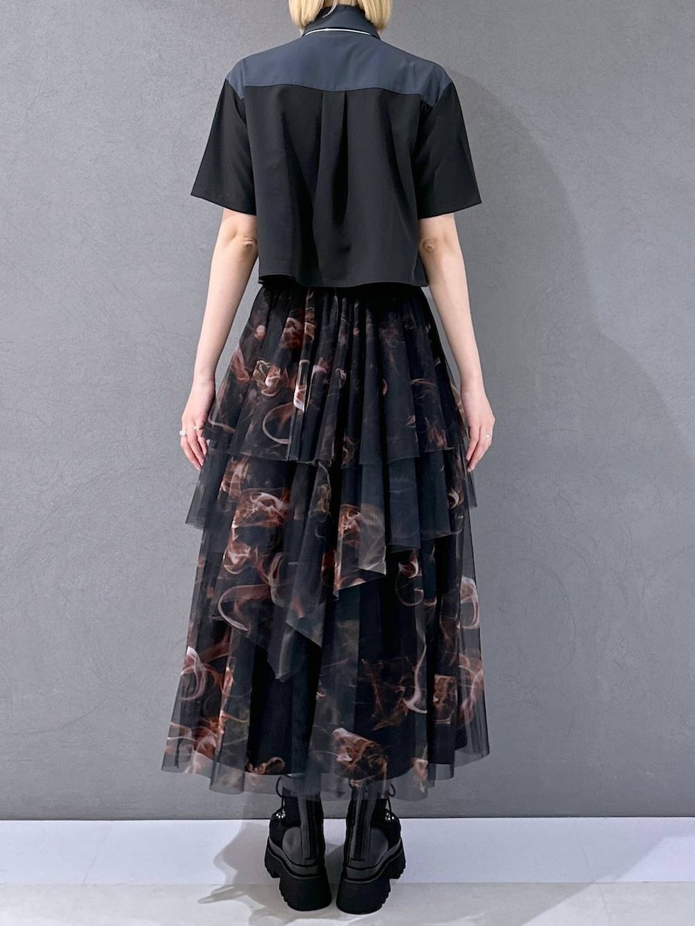 ブラック系のサンダル、オレンジ系のスカート、ブラック系のシャツ/ブラウスを着用したレディースの夏コーディネートの3枚目の写真