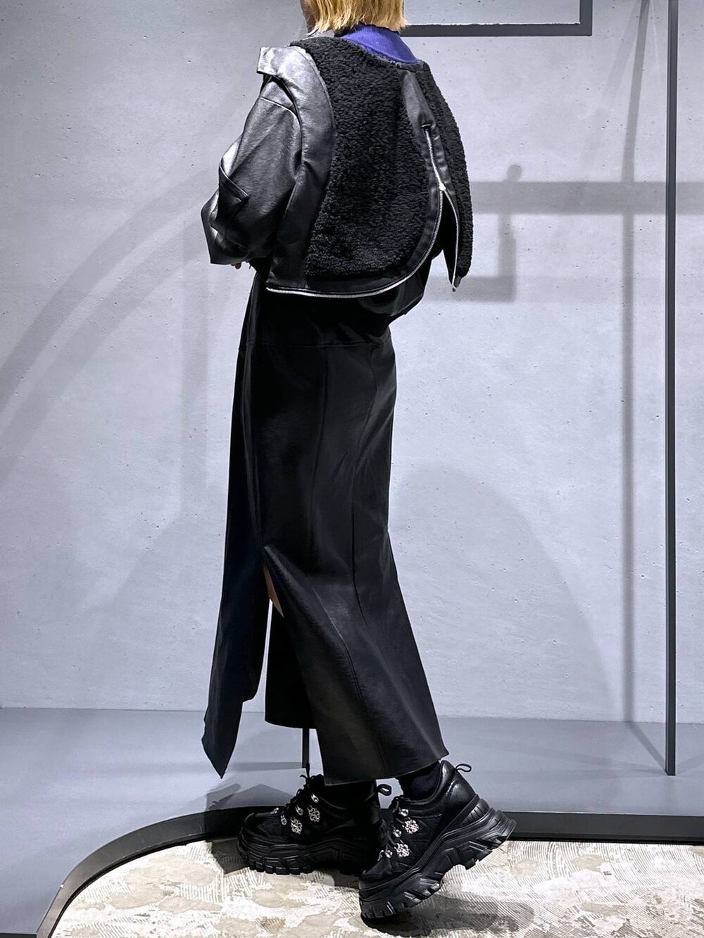 ブラック系のスニーカー、ブラック系のスカート、パープル系のニット/セーターを着用したレディースの冬コーディネートの5枚目の写真