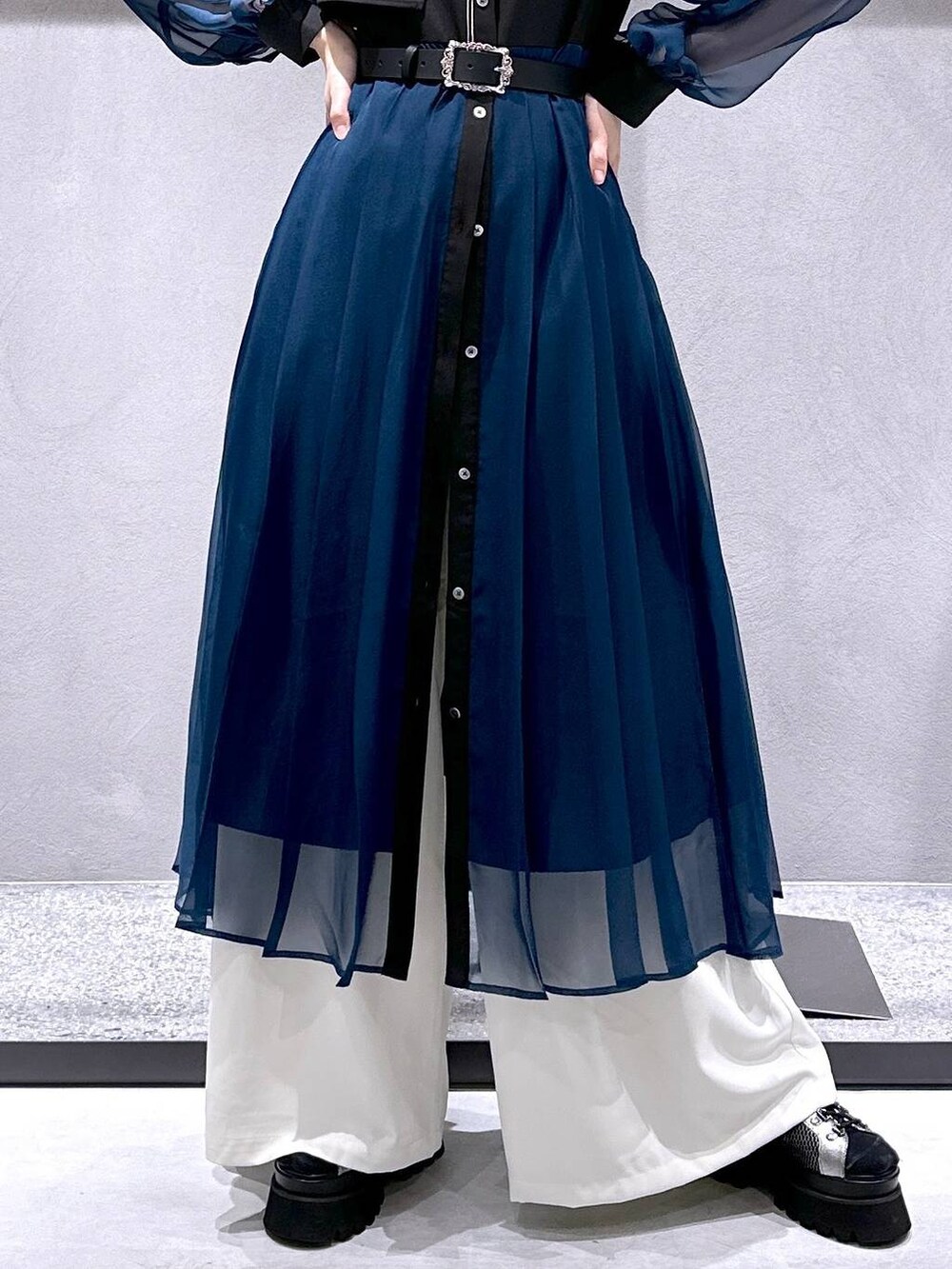 シルバー系のサンダル、ブラック系のワンピース、ホワイト系のスラックスを着用したレディースの春コーディネートの7枚目の写真