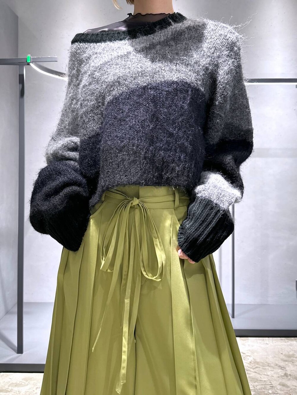 ブラック系のニット/セーター、グリーン系のその他パンツ、ブラック系のスニーカーを着用したレディースの冬コーディネートの4枚目の写真