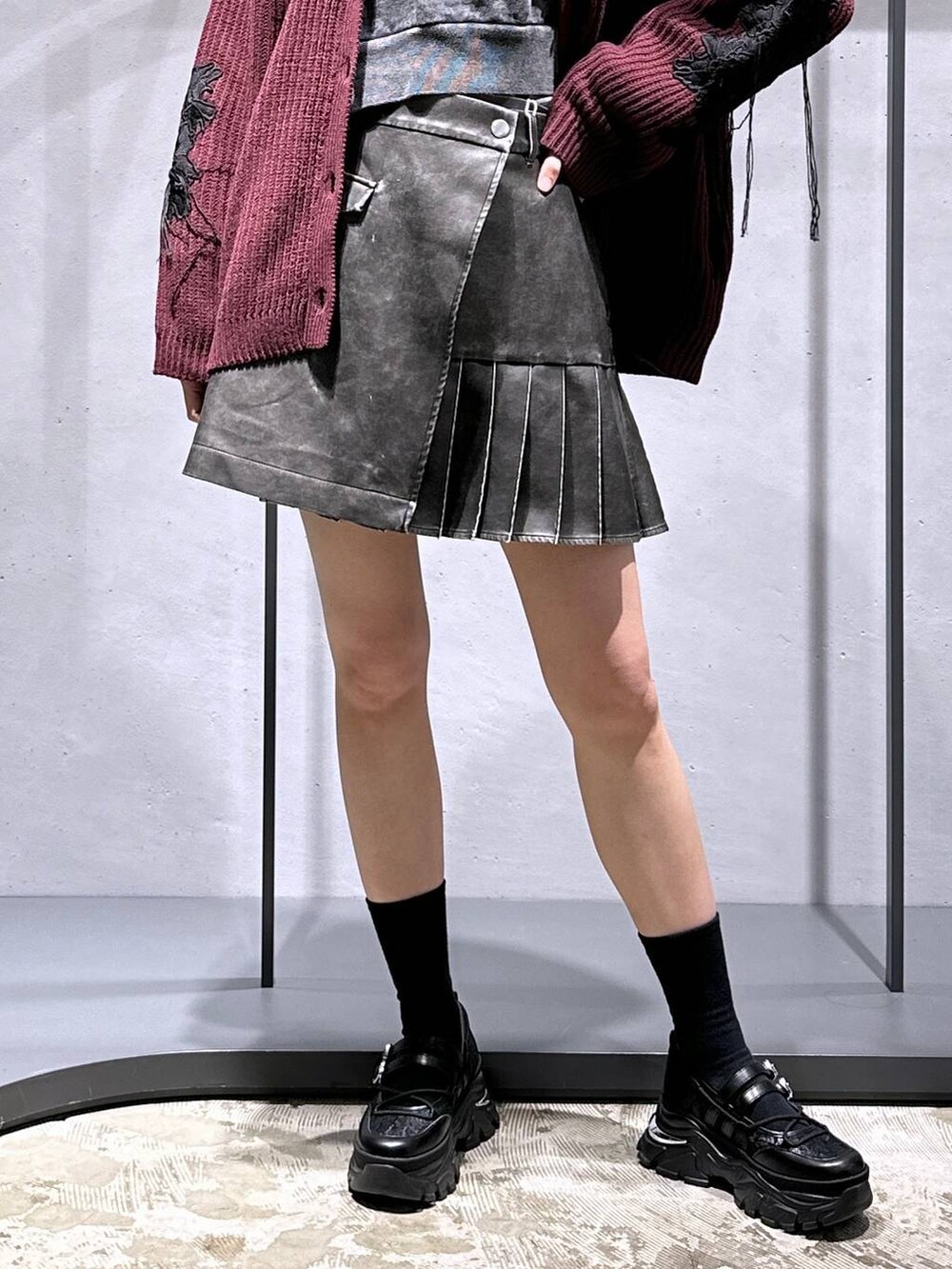 レッド系のカーディガン/ボレロ、ブラック系のスウェット、ブラック系のスニーカーを着用したレディースの冬コーディネートの6枚目の写真