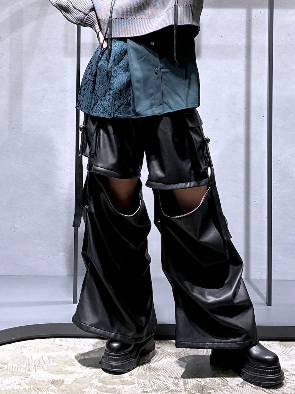 ブラック系のカーゴパンツ、ブラック系のブーツ、グレー系のニット/セーターを着用したレディースの冬コーディネートの6枚目の写真