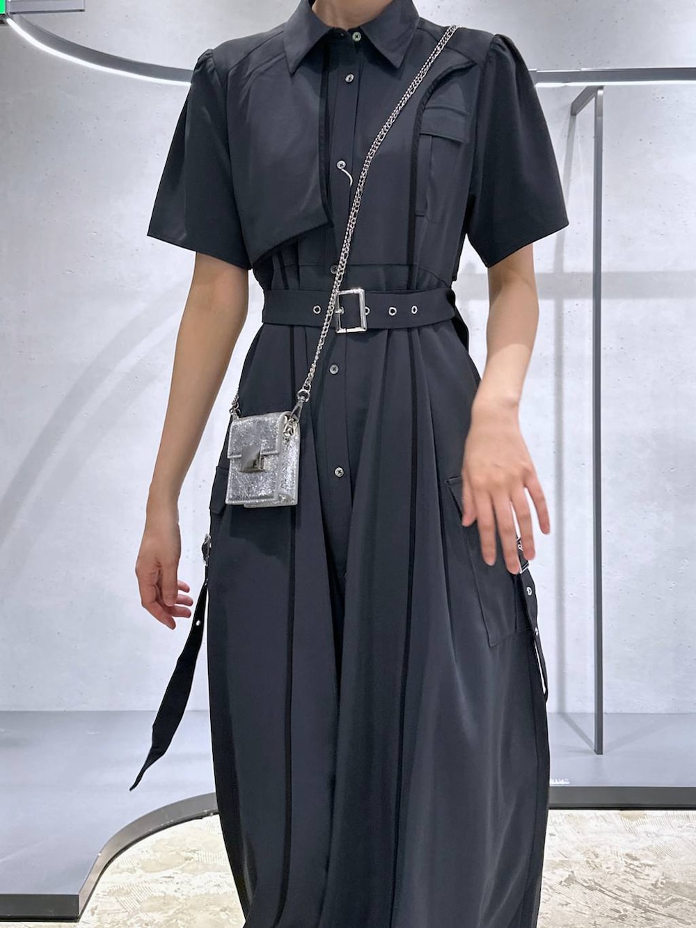 ブラック系のサンダル、シルバー系のショルダーバッグ、グレー系のワンピースを着用したレディースの夏コーディネートの2枚目の写真