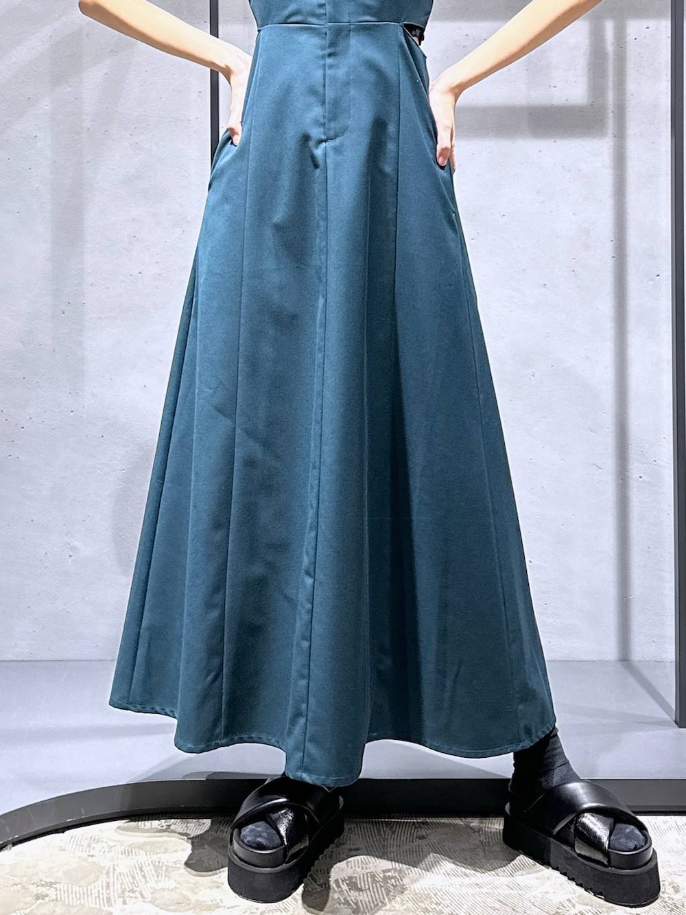 ブラック系のサンダル、グレー系のニット/セーター、グリーン系のワンピースを着用したレディースの春コーディネートの8枚目の写真