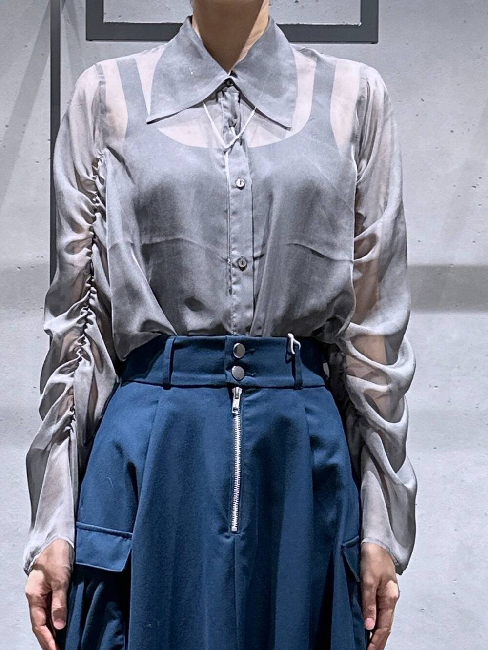 ブラック系のサンダル、ブルー系のスカート、シルバー系のネックレスを着用したレディースの春コーディネートの5枚目の写真