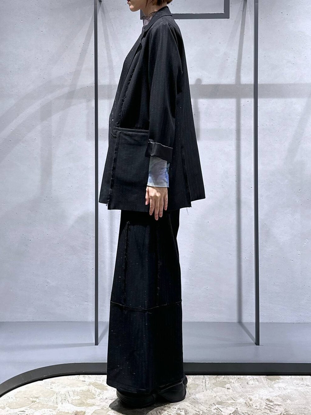 パープル系のTシャツ/カットソー、ブラック系のブーツ、ブラック系のテーラードジャケットを着用したレディースの秋コーディネートの2枚目の写真