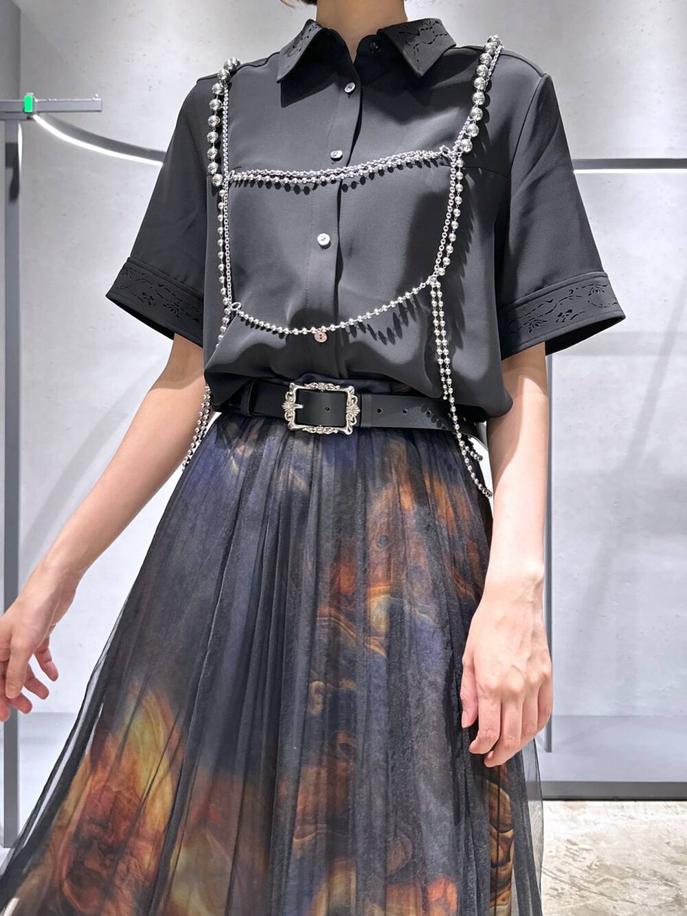 ブラック系のシャツ/ブラウス、ブラック系のサンダル、オレンジ系のスカートを着用したレディースの夏コーディネートの5枚目の写真