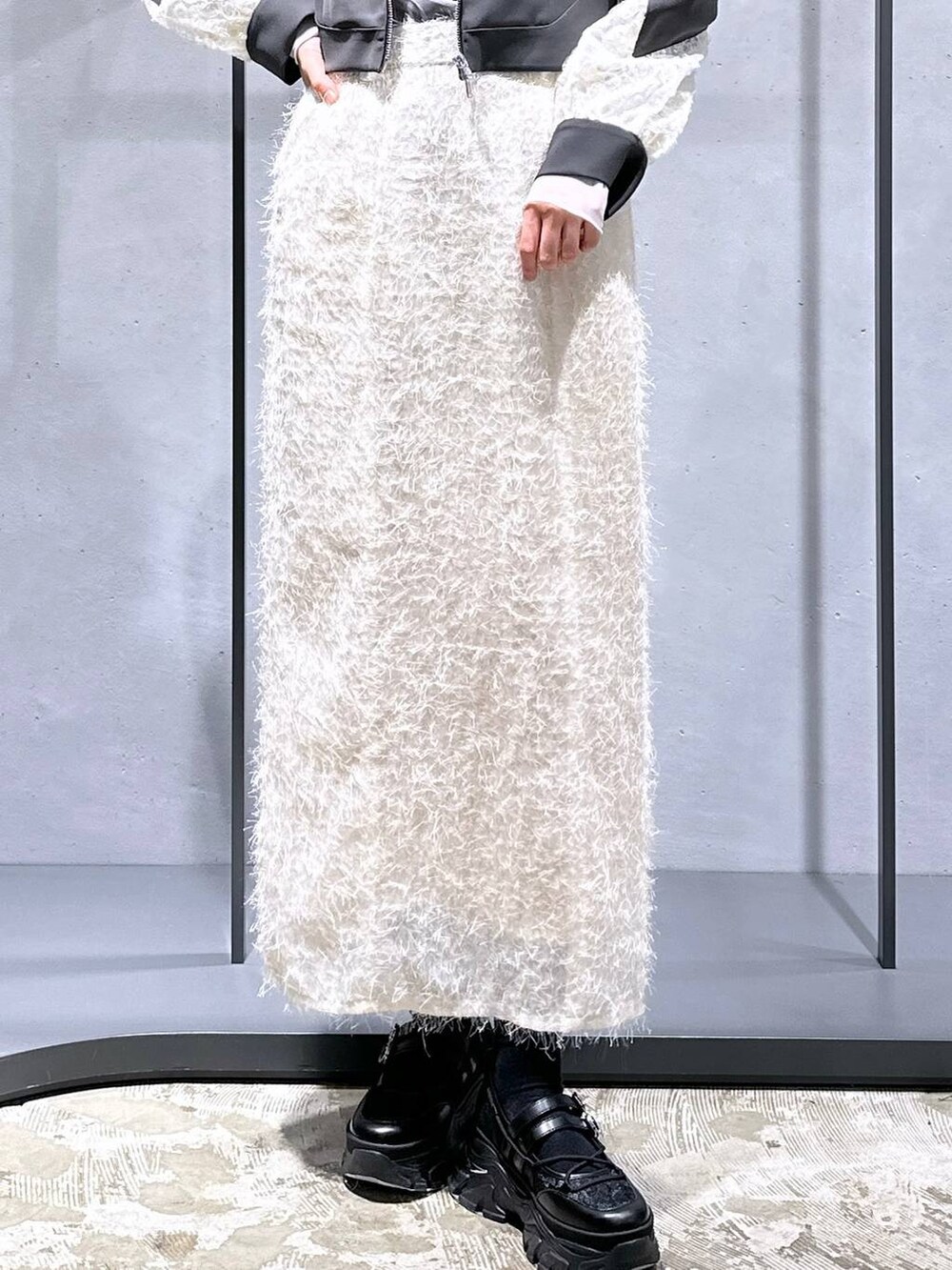 ブラック系のTシャツ/カットソー、ブラック系のスニーカー、ホワイト系のスカートを着用したレディースの冬コーディネートの6枚目の写真