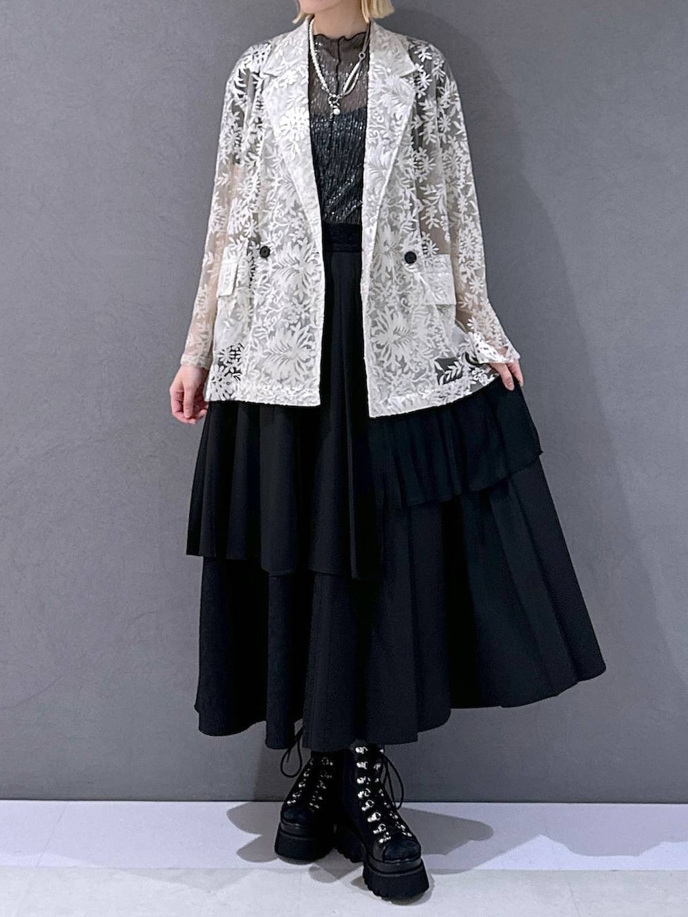 ブラック系のサンダル、ブラック系のTシャツ/カットソー、ホワイト系のテーラードジャケットを着用したレディースの夏コーディネートの4枚目の写真