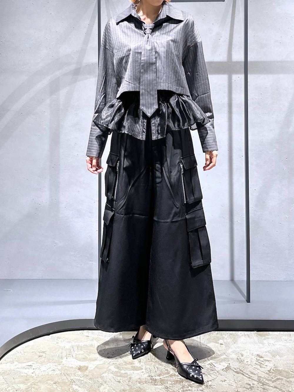 ブラック系のパンプス、ブラック系のベスト、ブラック系のカーゴパンツを着用したレディースの夏コーディネートの4枚目の写真