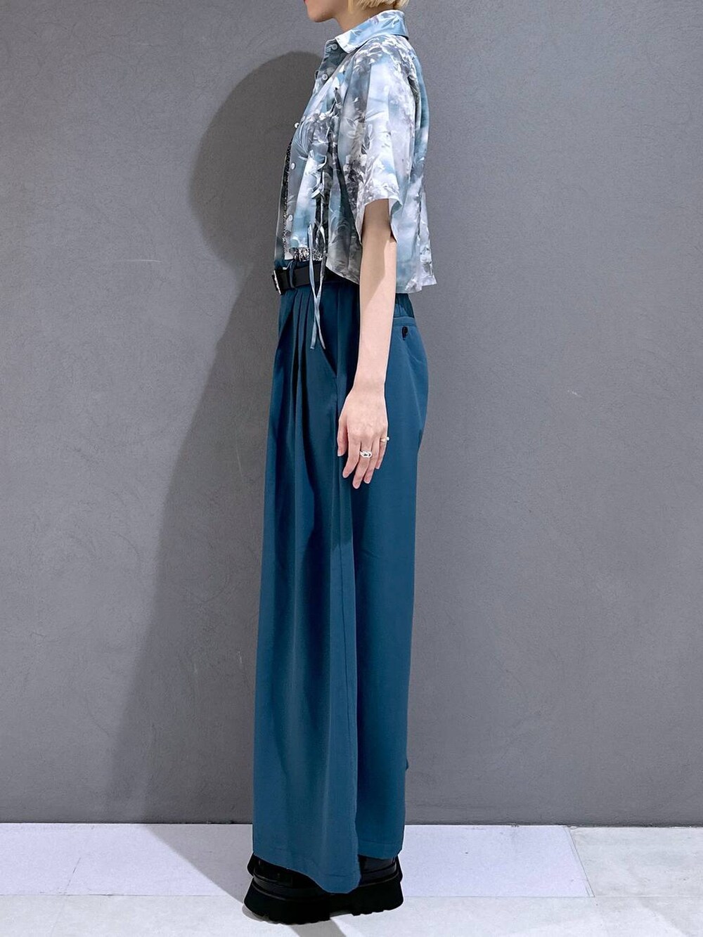 ブラック系のサンダル、ブルー系のスラックス、ブラック系のTシャツ/カットソーを着用したレディースの春コーディネートの2枚目の写真