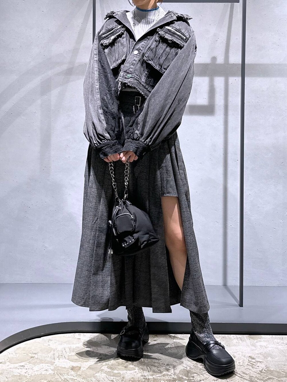 ブラック系のショルダーバッグ、シルバー系のブーツ、グレー系のニット/セーターを着用したレディースの秋コーディネートの4枚目の写真