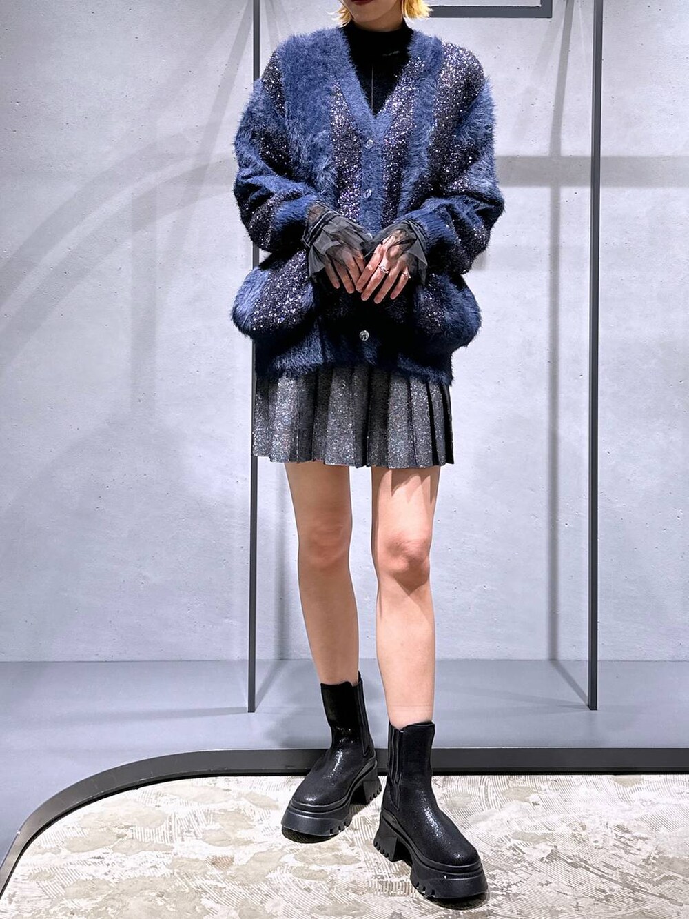 ブラック系のTシャツ/カットソー、ブラック系のブーツ、ブラック系のスカートを着用したレディースの冬コーディネートの4枚目の写真