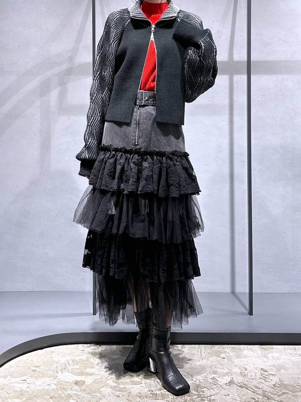 ブラック系のブーツ、ブラック系のカーディガン/ボレロ、レッド系のニット/セーターを着用したレディースの秋コーディネートの4枚目の写真