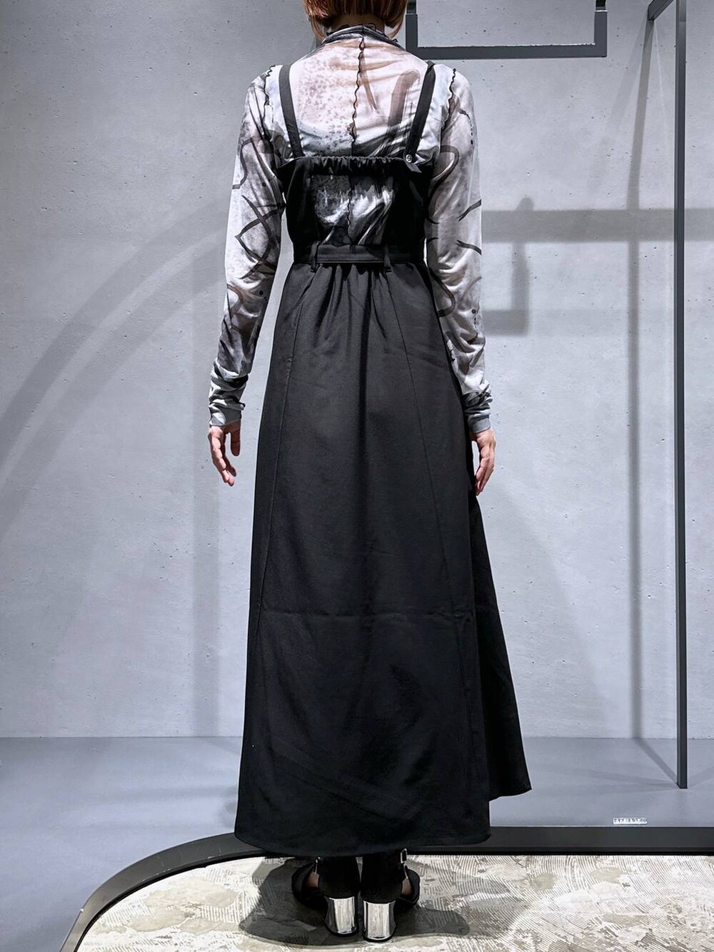 ブラック系のサンダル、ブラック系のジャンパースカート、ホワイト系のTシャツ/カットソーを着用したレディースの夏コーディネートの6枚目の写真