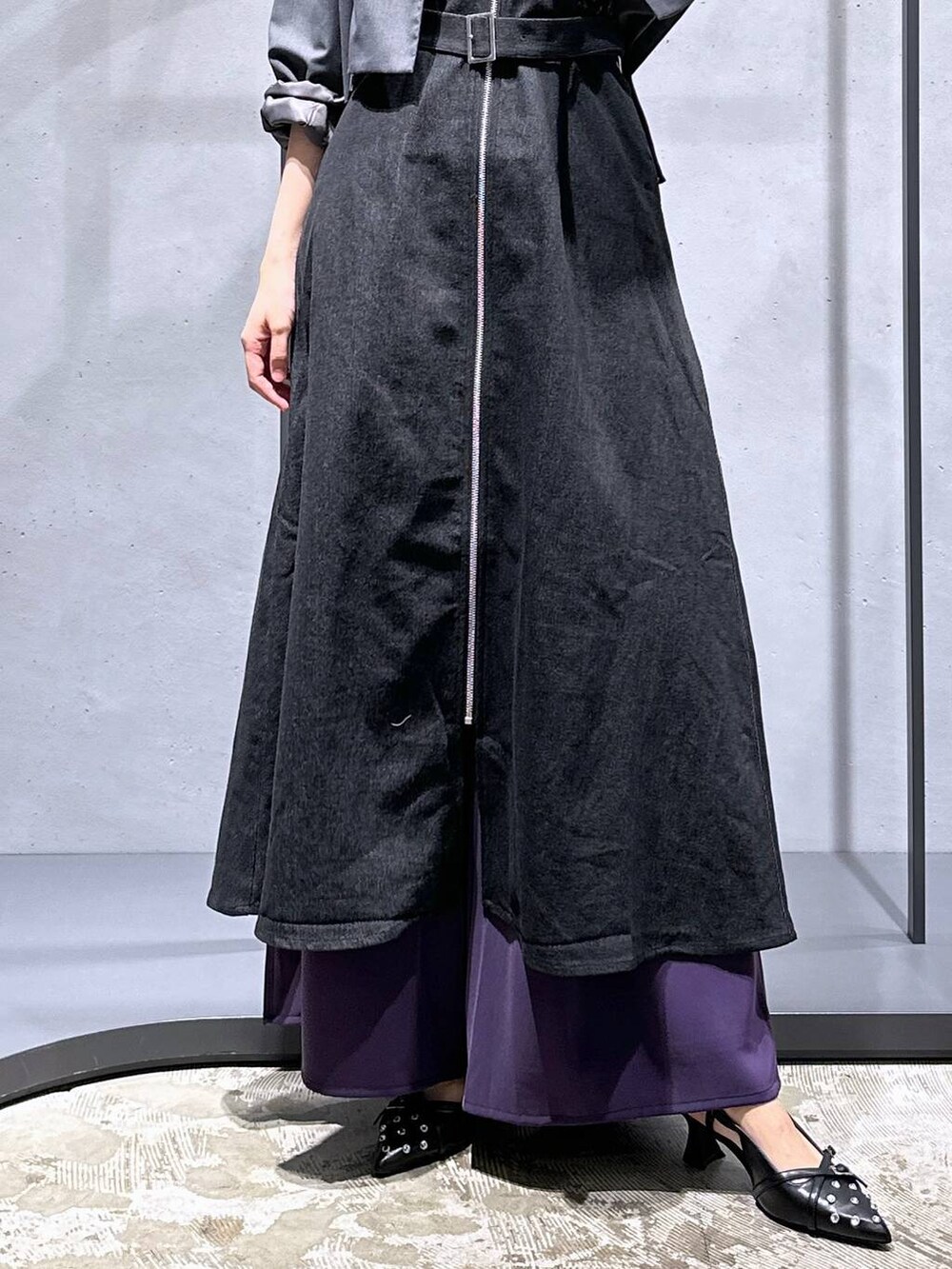 グレー系のテーラードジャケット、ブラック系のパンプス、パープル系のスラックスを着用したレディースの夏コーディネートの6枚目の写真