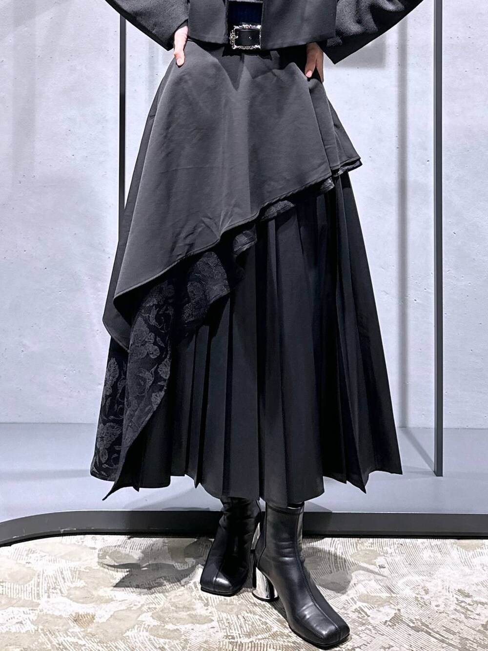 ブラック系のスカート、ブルー系のニット/セーター、ブラック系のブーツを着用したレディースの秋コーディネートの6枚目の写真