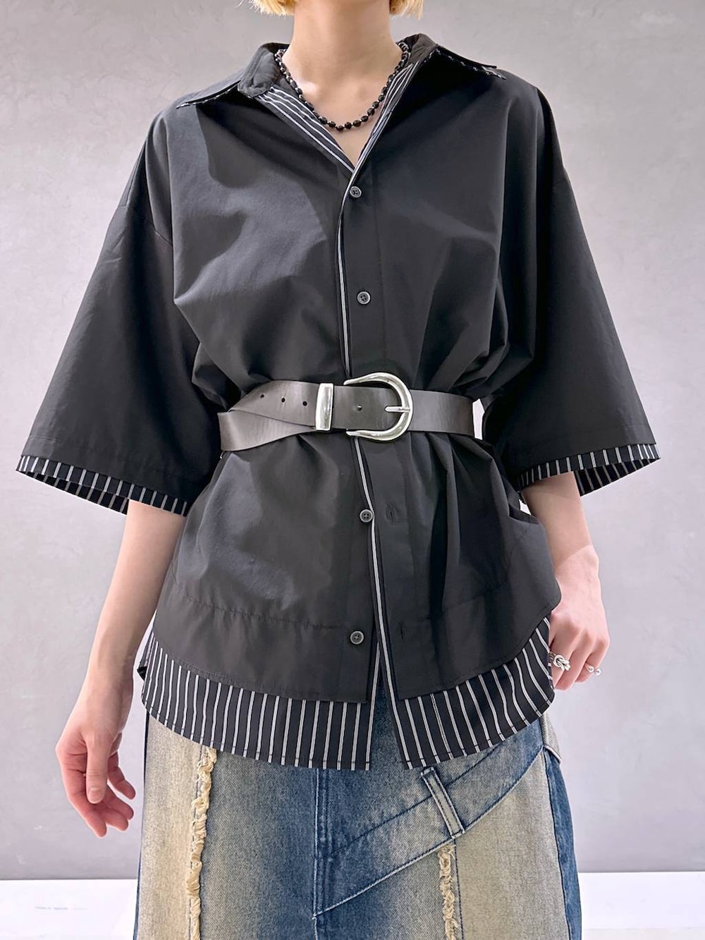 ブラック系のサンダル、ブルー系のデニムスカート、ブラック系のシャツ/ブラウスを着用したレディースの春コーディネートの5枚目の写真