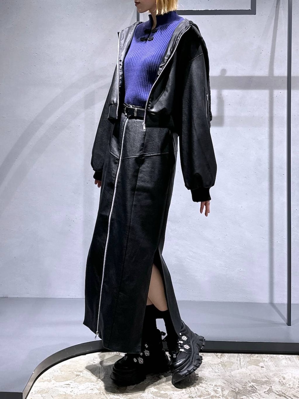 ブラック系のスニーカー、ブラック系のスカート、パープル系のニット/セーターを着用したレディースの冬コーディネートの4枚目の写真