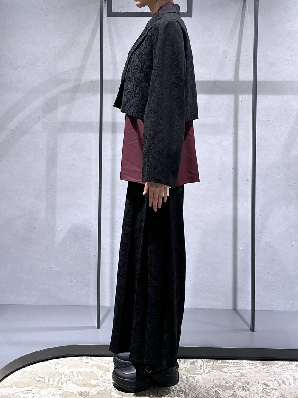 ブラック系のブーツ、ブラック系のテーラードジャケット、レッド系のシャツ/ブラウスを着用したレディースの秋コーディネートの2枚目の写真