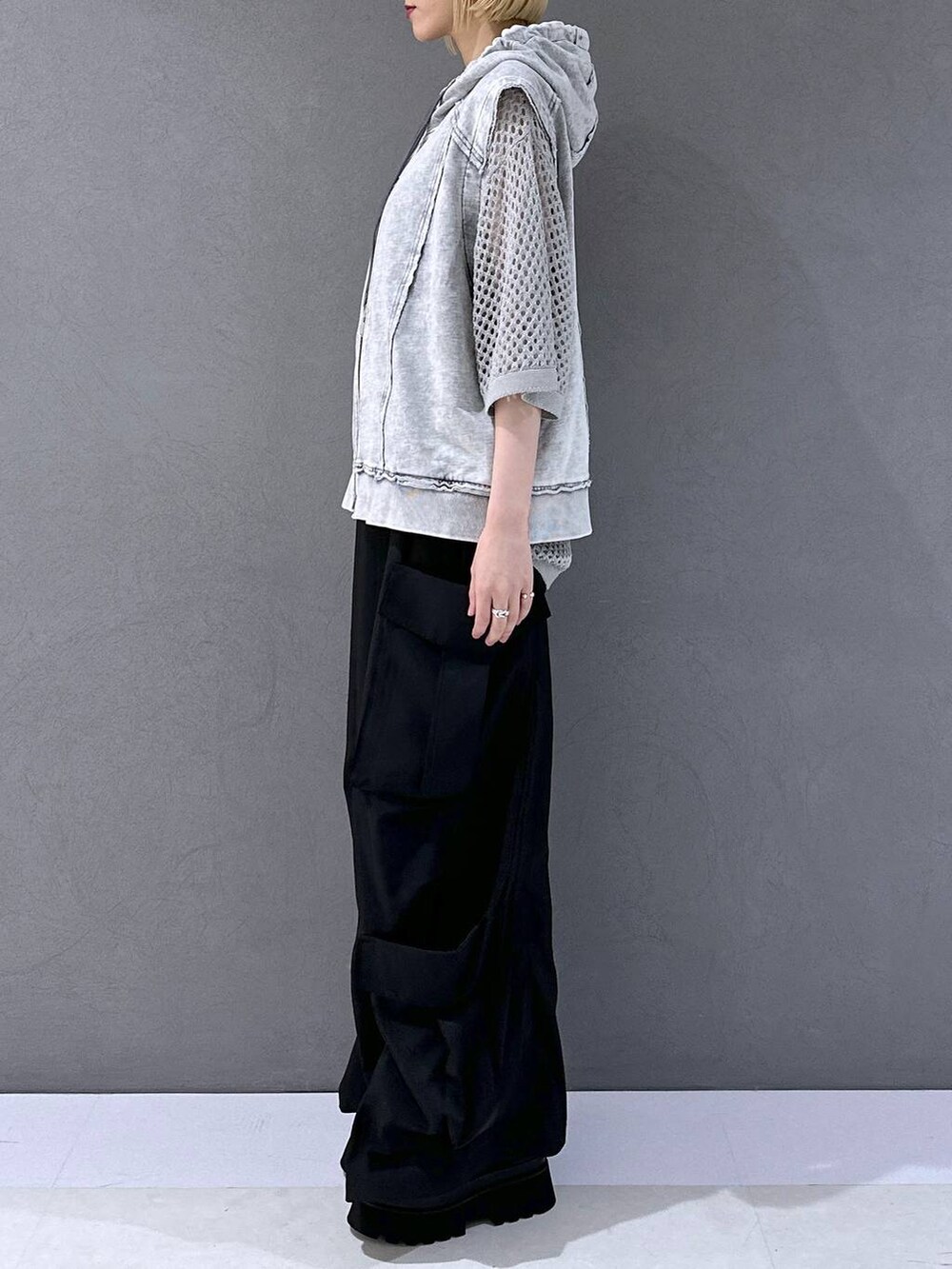 ブラック系のサンダル、ブラック系のカーゴパンツ、グレー系のニット/セーターを着用したレディースの春コーディネートの2枚目の写真