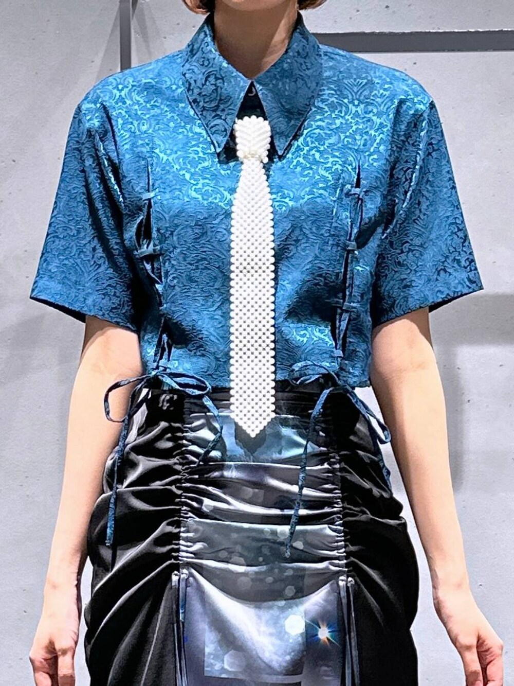 グリーン系のシャツ/ブラウス、ブラック系のサンダル、ブラック系のスカートを着用したレディースの夏コーディネートの7枚目の写真