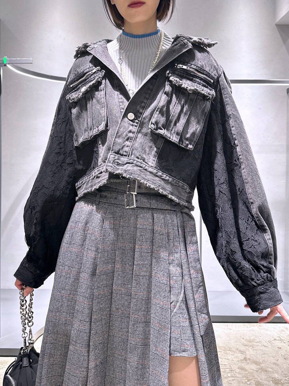 ブラック系のショルダーバッグ、シルバー系のブーツ、グレー系のニット/セーターを着用したレディースの秋コーディネートの5枚目の写真