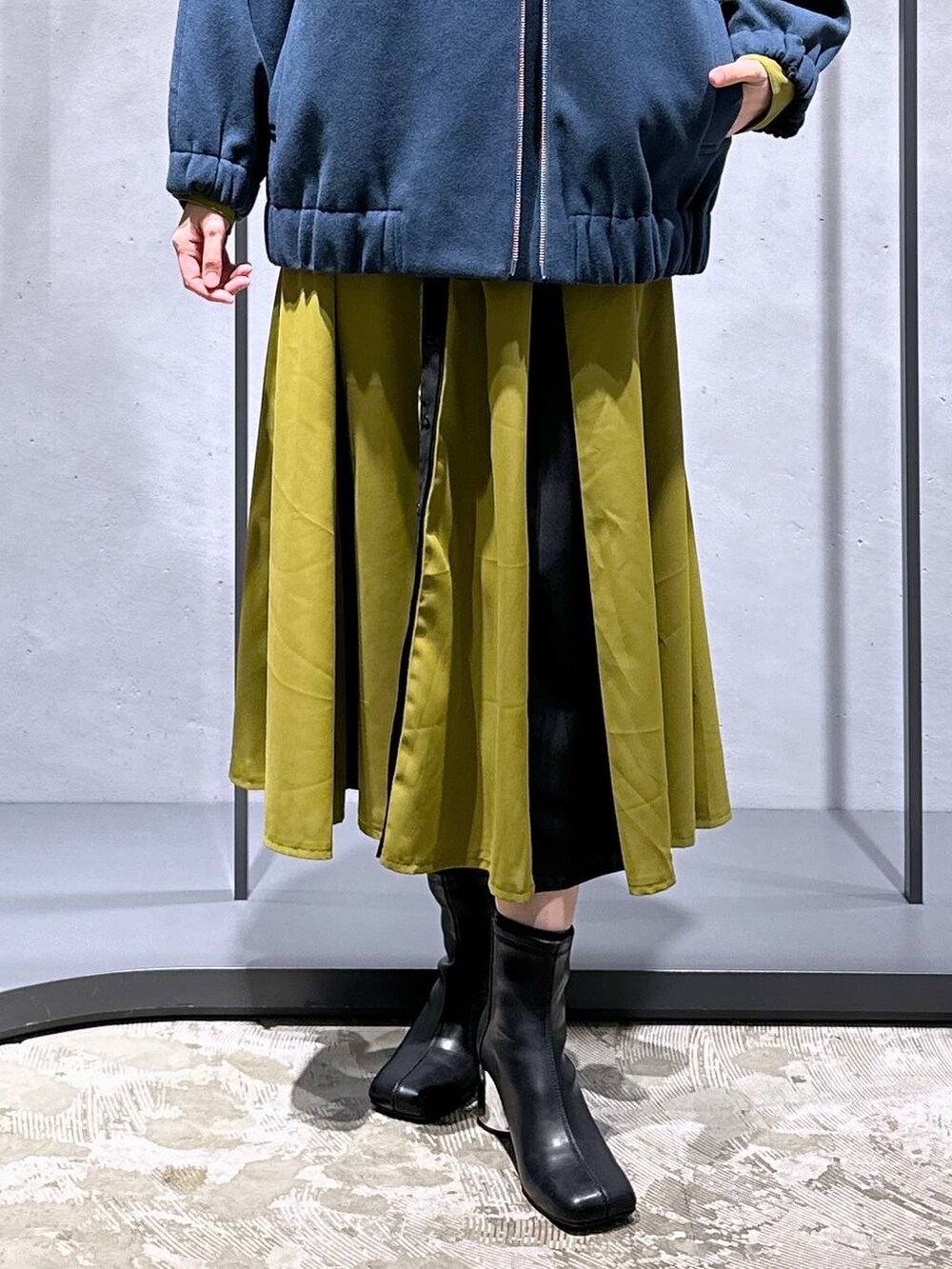 ブラック系のブーツ、ブルー系のブルゾン、イエロー系のワンピースを着用したレディースの冬コーディネートの6枚目の写真