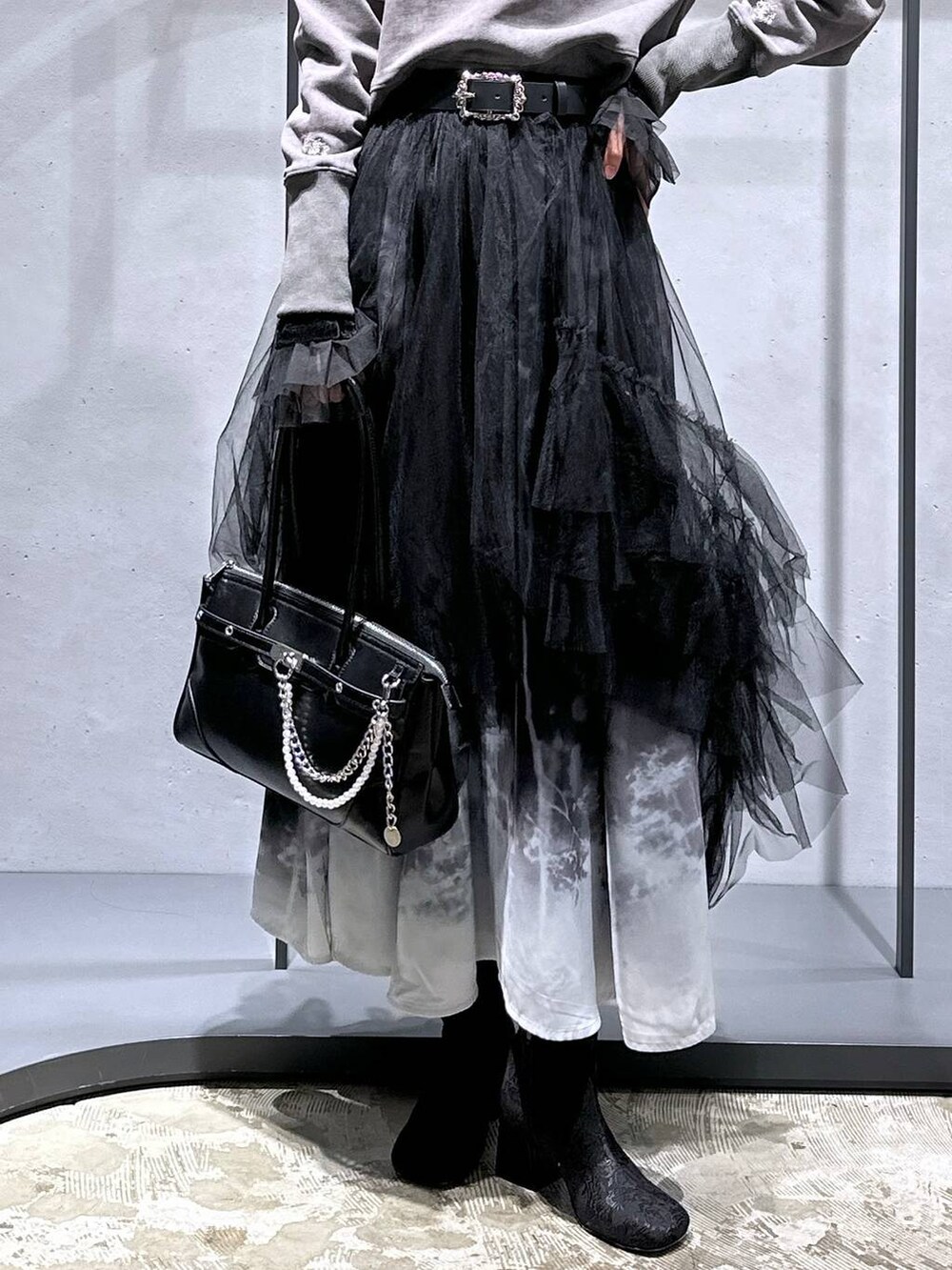 ブラック系のTシャツ/カットソー、ブラック系のブーツ、ブラック系のスウェットを着用したレディースの冬コーディネートの6枚目の写真