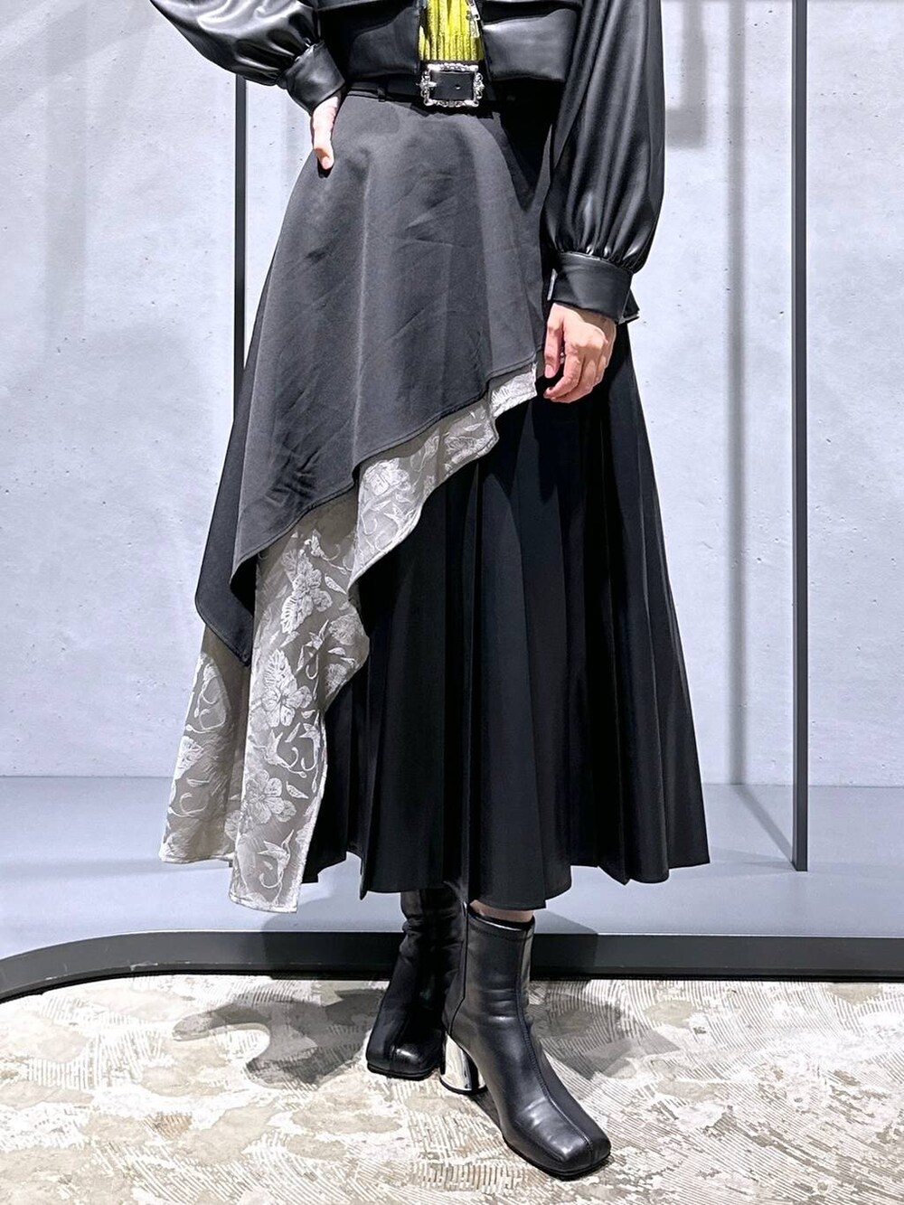 グレー系のスカート、イエロー系のニット/セーター、ブラック系のブーツを着用したレディースの秋コーディネートの6枚目の写真