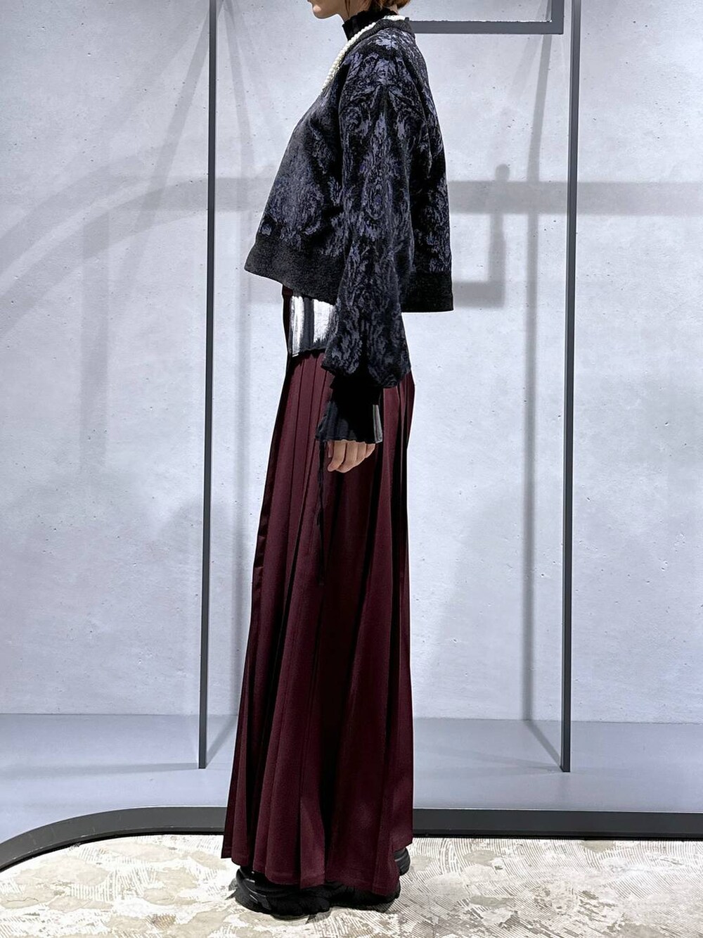 ブラック系のニット/セーター、ブラック系のローファー、レッド系のその他パンツを着用したレディースの秋コーディネートの2枚目の写真