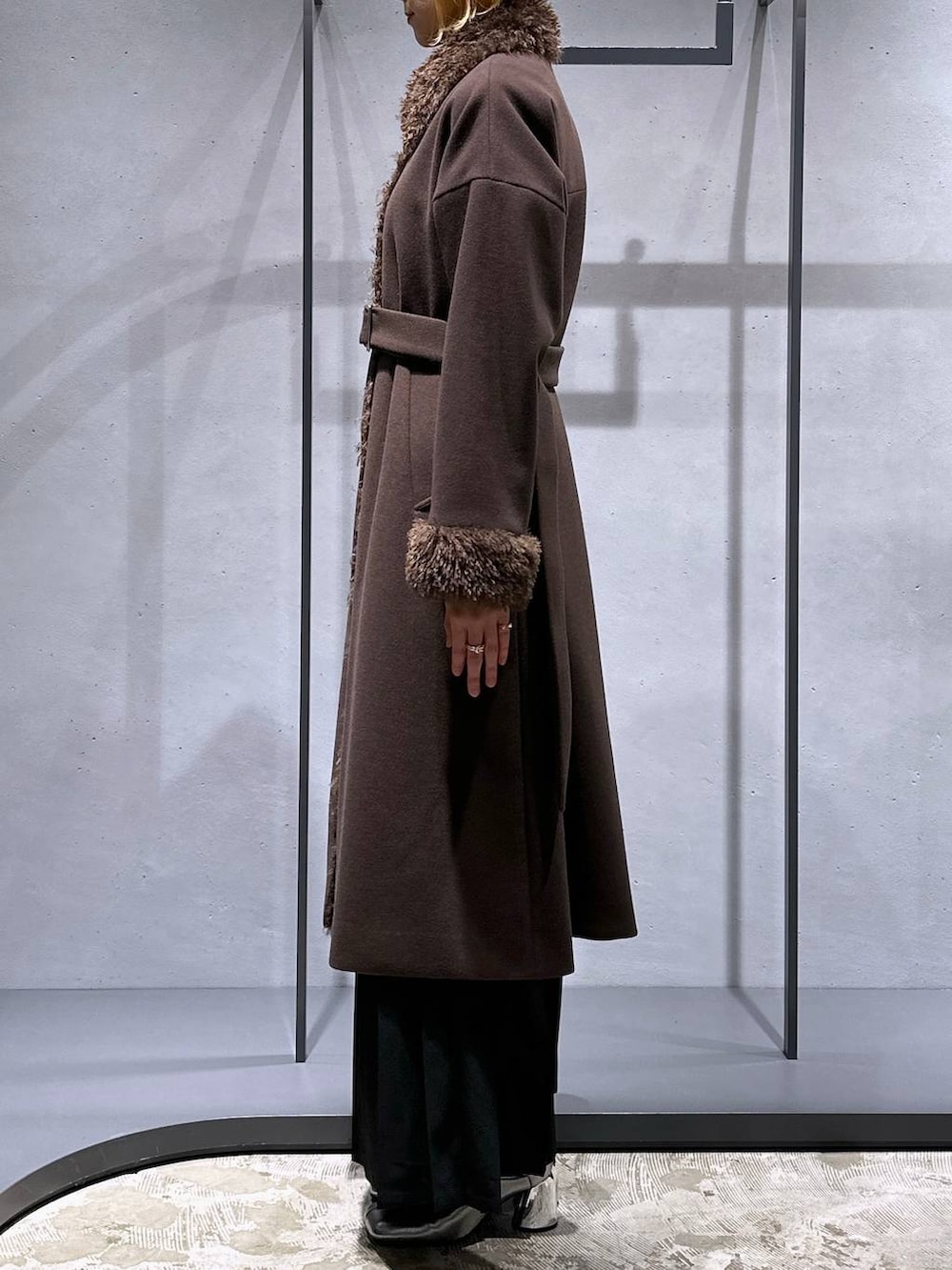 ホワイト系のニット/セーター、シルバー系のブーツ、ブラック系のショルダーバッグを着用したレディースの冬コーディネートの2枚目の写真