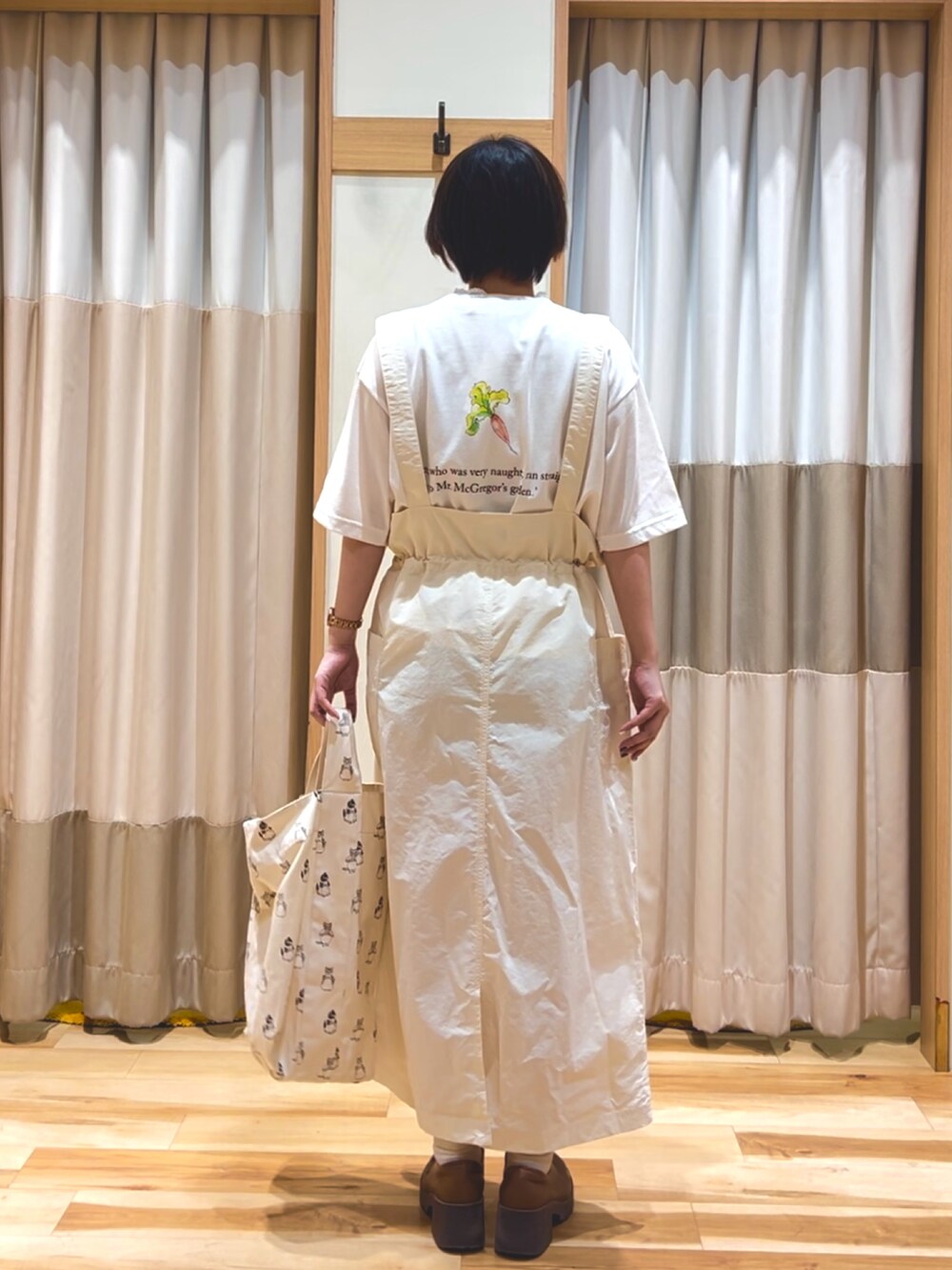 ホワイト系のTシャツ/カットソー、ホワイト系のスカート、ホワイト系のハンドバッグを着用したレディースの春コーディネートの2枚目の写真