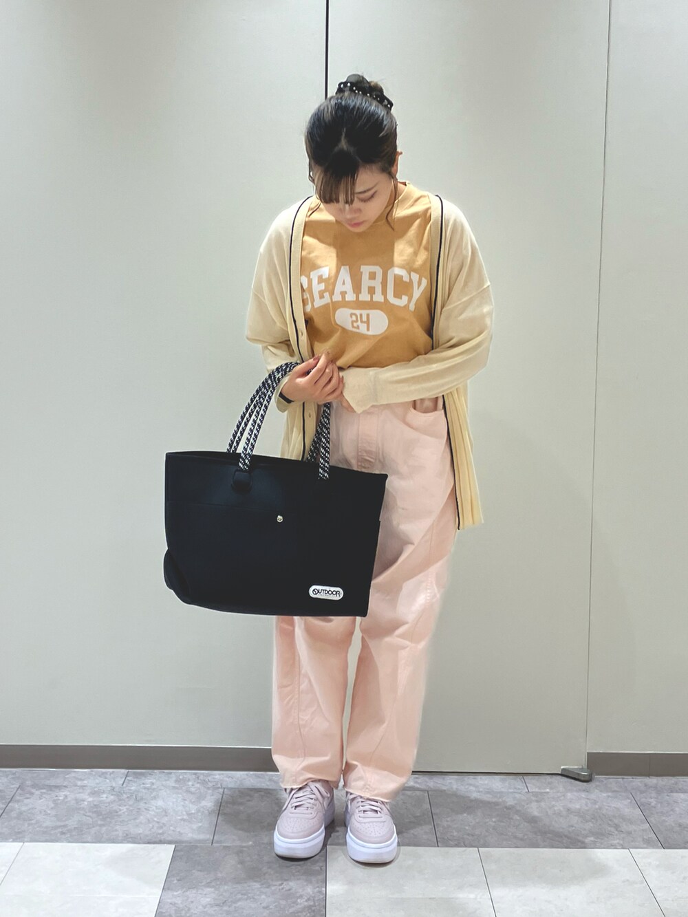 ブラック系のハンドバッグ、ピンク系のその他パンツ、イエロー系のTシャツ/カットソーを着用したレディースの春コーディネートの2枚目の写真