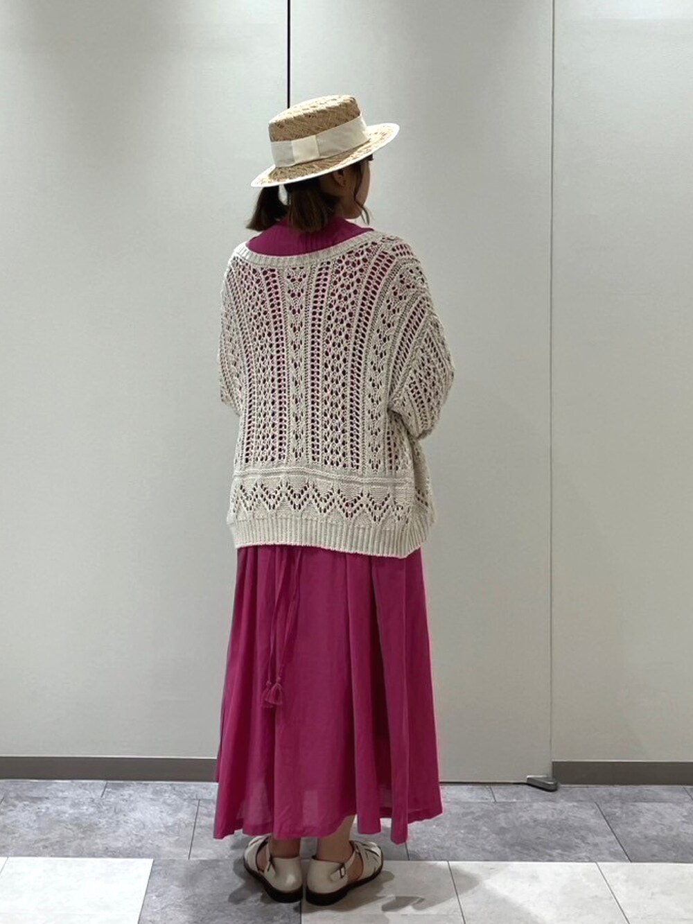 ピンク系のワンピース、ホワイト系のカーディガン/ボレロ、ホワイト系のハットを着用したレディースの春コーディネートの3枚目の写真