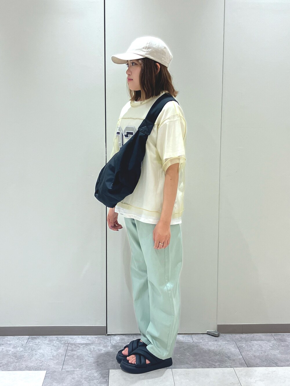 ブラック系のサンダル、ホワイト系のその他パンツ、ベージュ系のハンドバッグを着用したレディースの夏コーディネートの2枚目の写真