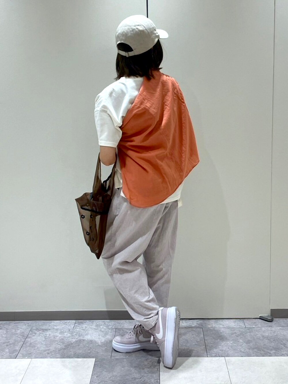 ブラック系のパンツ、ブラウン系のハンドバッグ、ホワイト系のTシャツ/カットソーを着用したレディースの春コーディネートの3枚目の写真