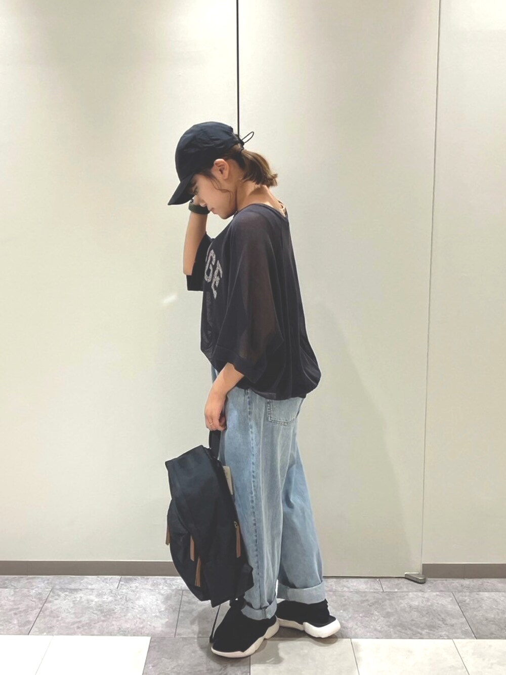 ブラック系のサンダル、ベージュ系のハンドバッグ、ブラック系のトップスを着用したレディースの春コーディネートの2枚目の写真