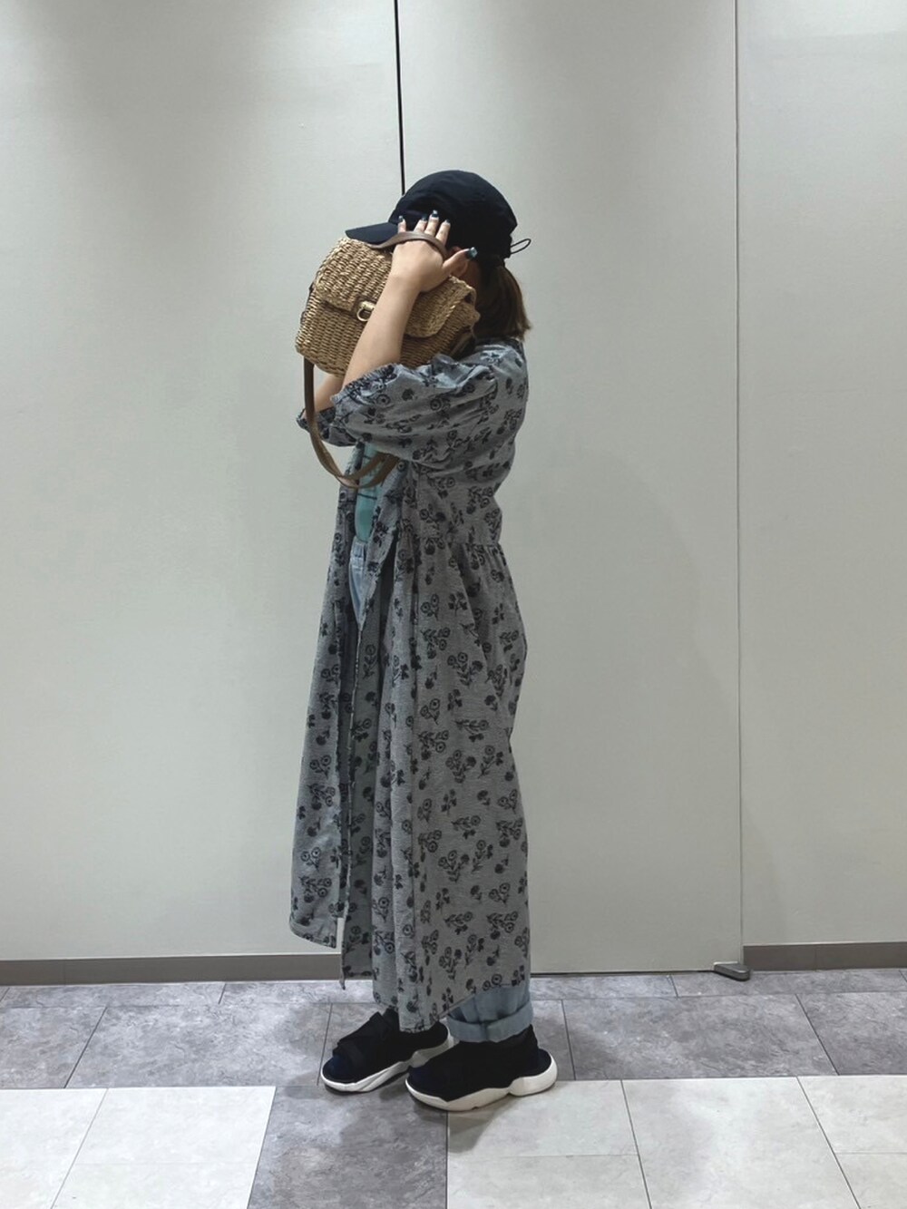 ホワイト系のハンドバッグ、グリーン系のTシャツ/カットソー、ブラック系のワンピースを着用したレディースの春コーディネートの2枚目の写真