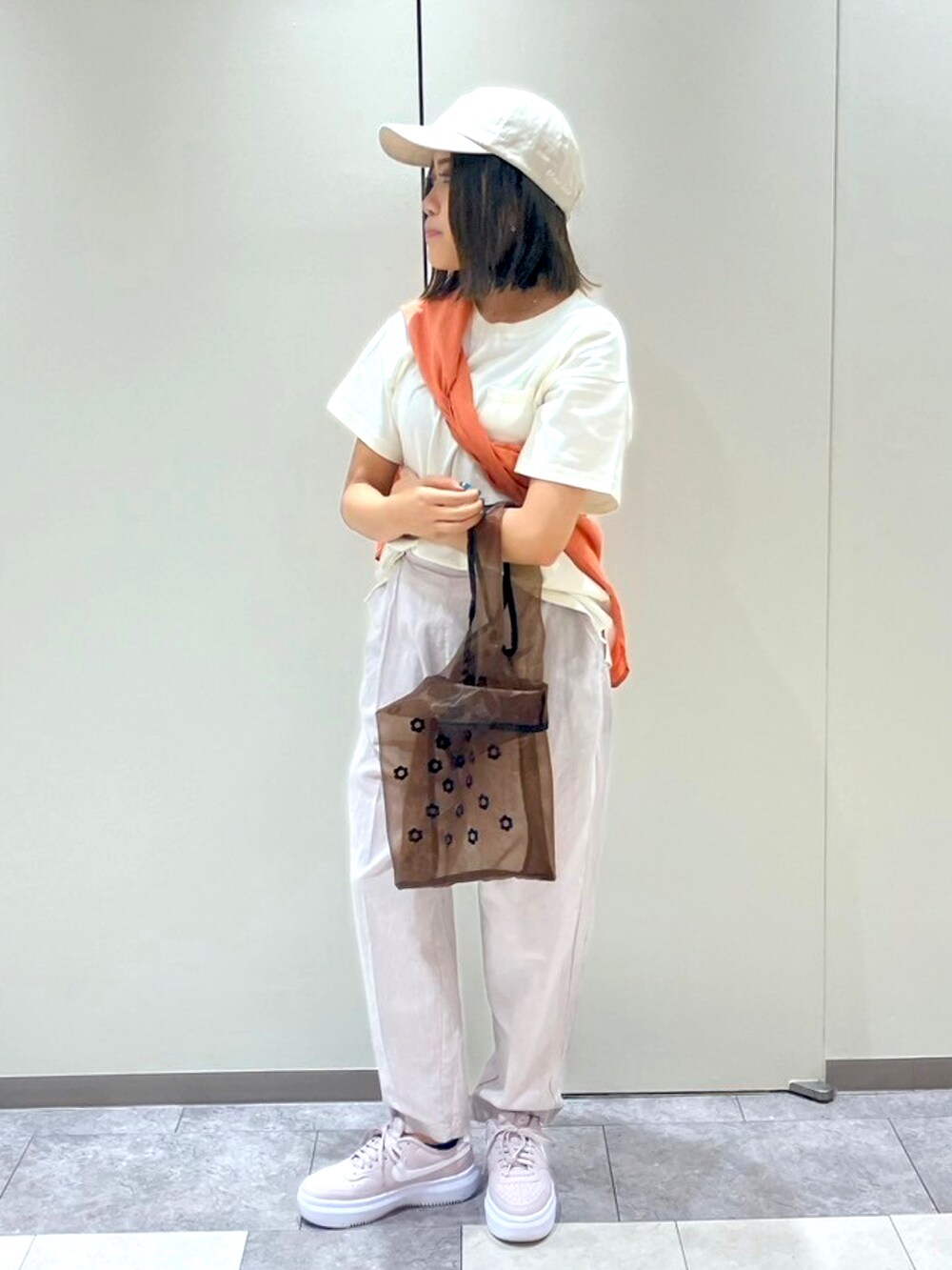 ブラック系のパンツ、ブラウン系のハンドバッグ、ホワイト系のTシャツ/カットソーを着用したレディースの春コーディネートの2枚目の写真