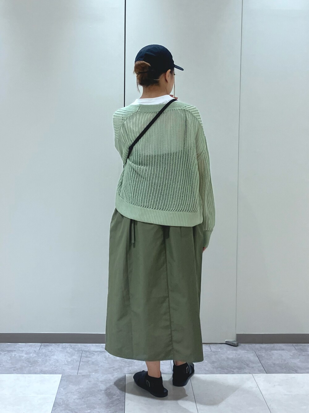 ブラック系のサンダル、グリーン系のワンピース、ブラック系のハンドバッグを着用したレディースの春コーディネートの5枚目の写真