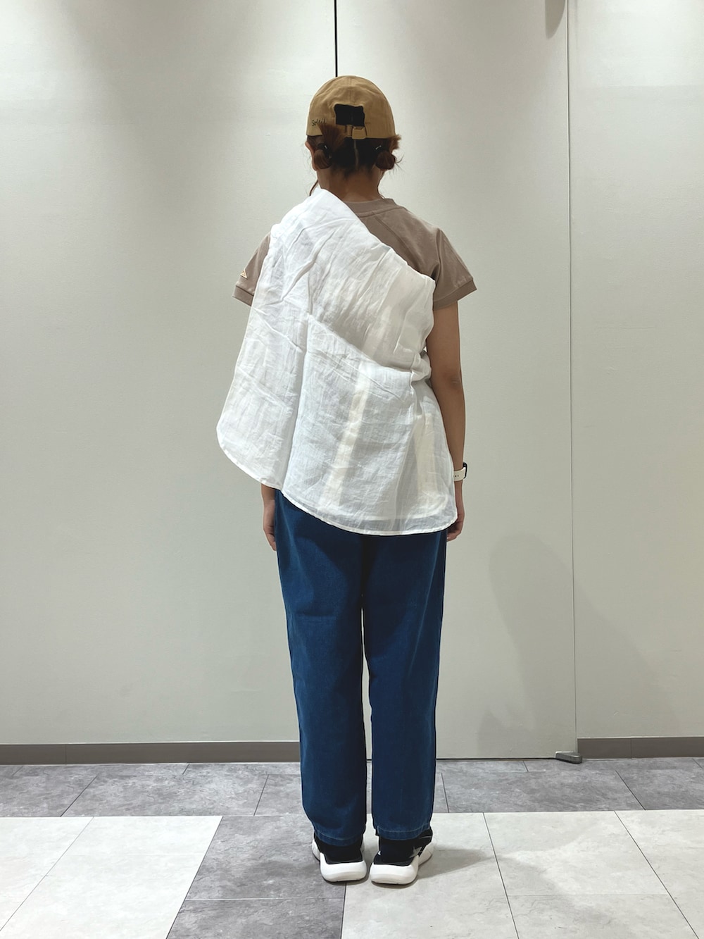 ブラック系のサンダル、ブルー系のデニムパンツ、ホワイト系のシャツ/ブラウスを着用したレディースの春コーディネートの2枚目の写真