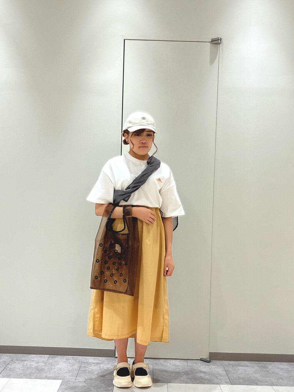 ベージュ系のスニーカー、ホワイト系のワンピース、ホワイト系のハンドバッグを着用したレディースの春コーディネートの3枚目の写真