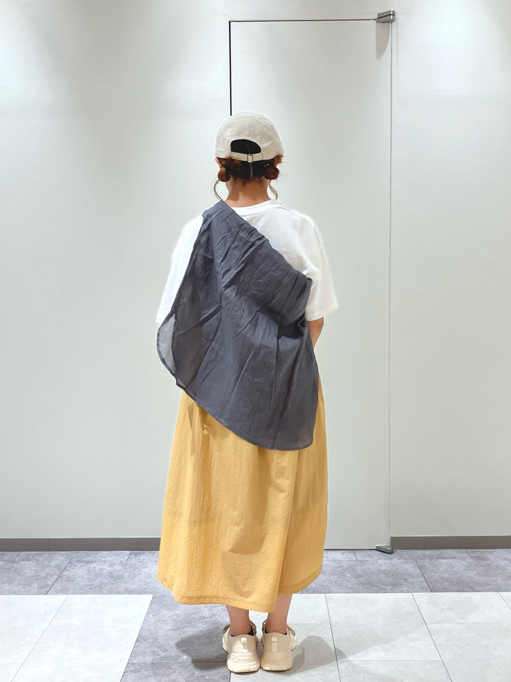 ベージュ系のスニーカー、ホワイト系のワンピース、ホワイト系のハンドバッグを着用したレディースの春コーディネートの4枚目の写真