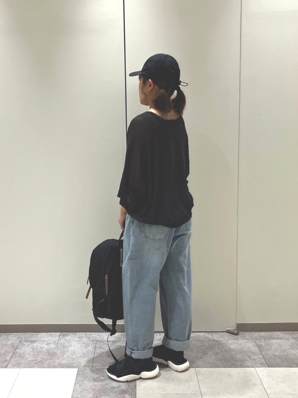 ブラック系のサンダル、ベージュ系のハンドバッグ、ブラック系のトップスを着用したレディースの春コーディネートの3枚目の写真